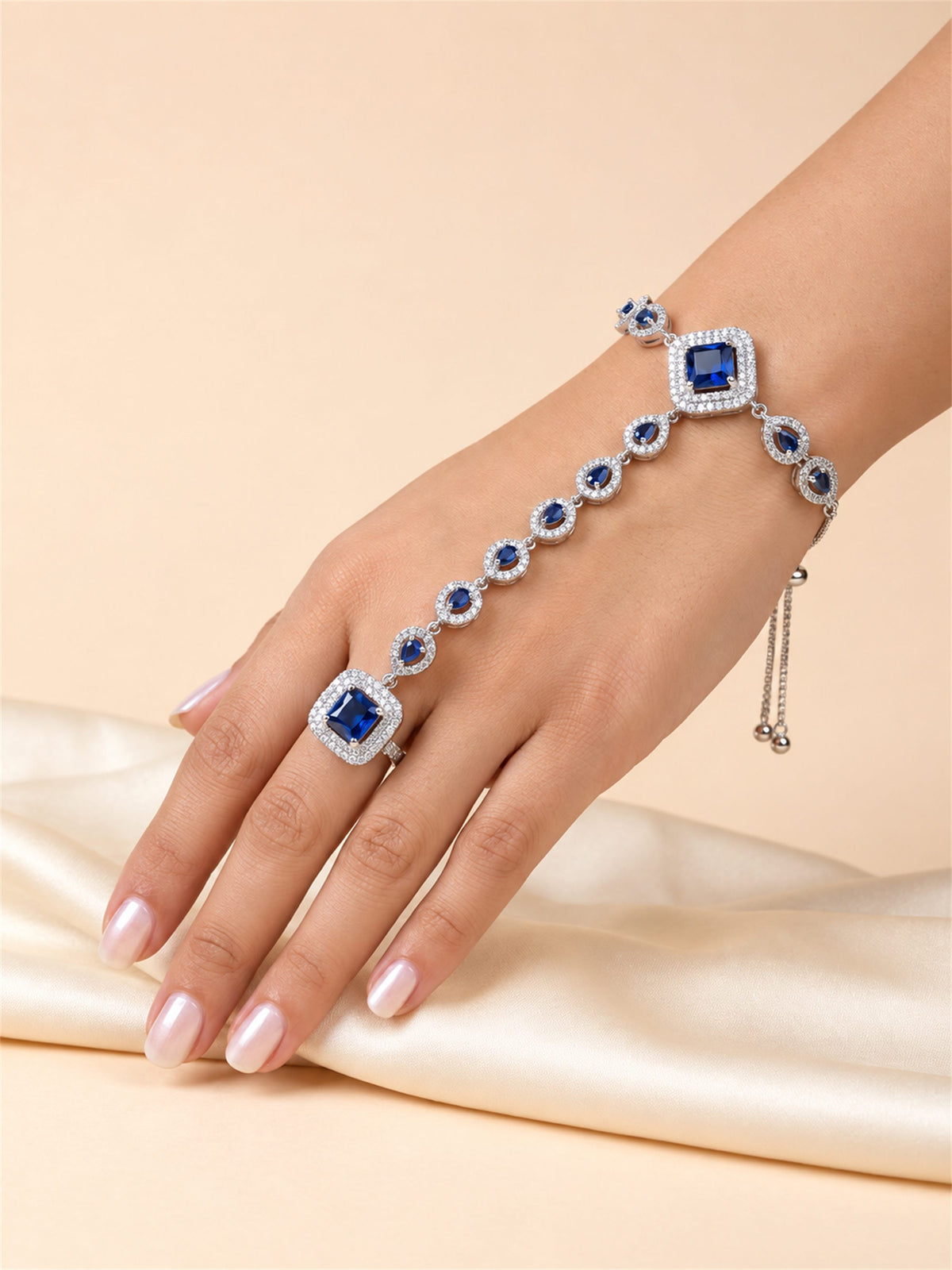 Blue silver-plated square halo and teardrop hathphool worn on hand