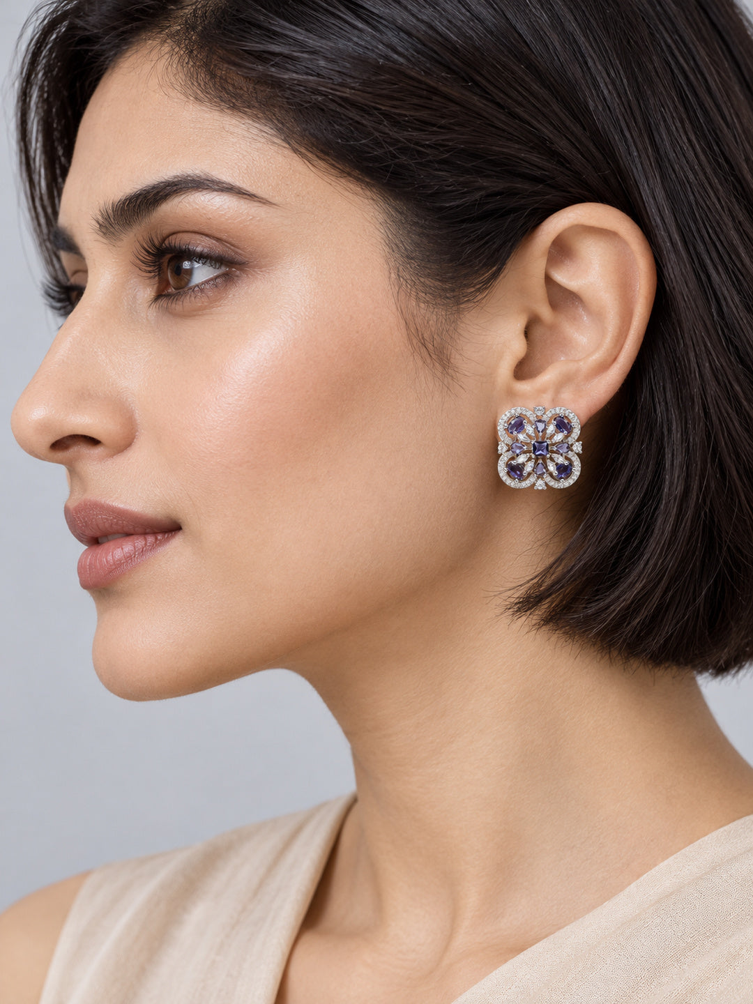 Purple Scrollwork Floral Stud Earrings in silver plating worn by a model, close-up