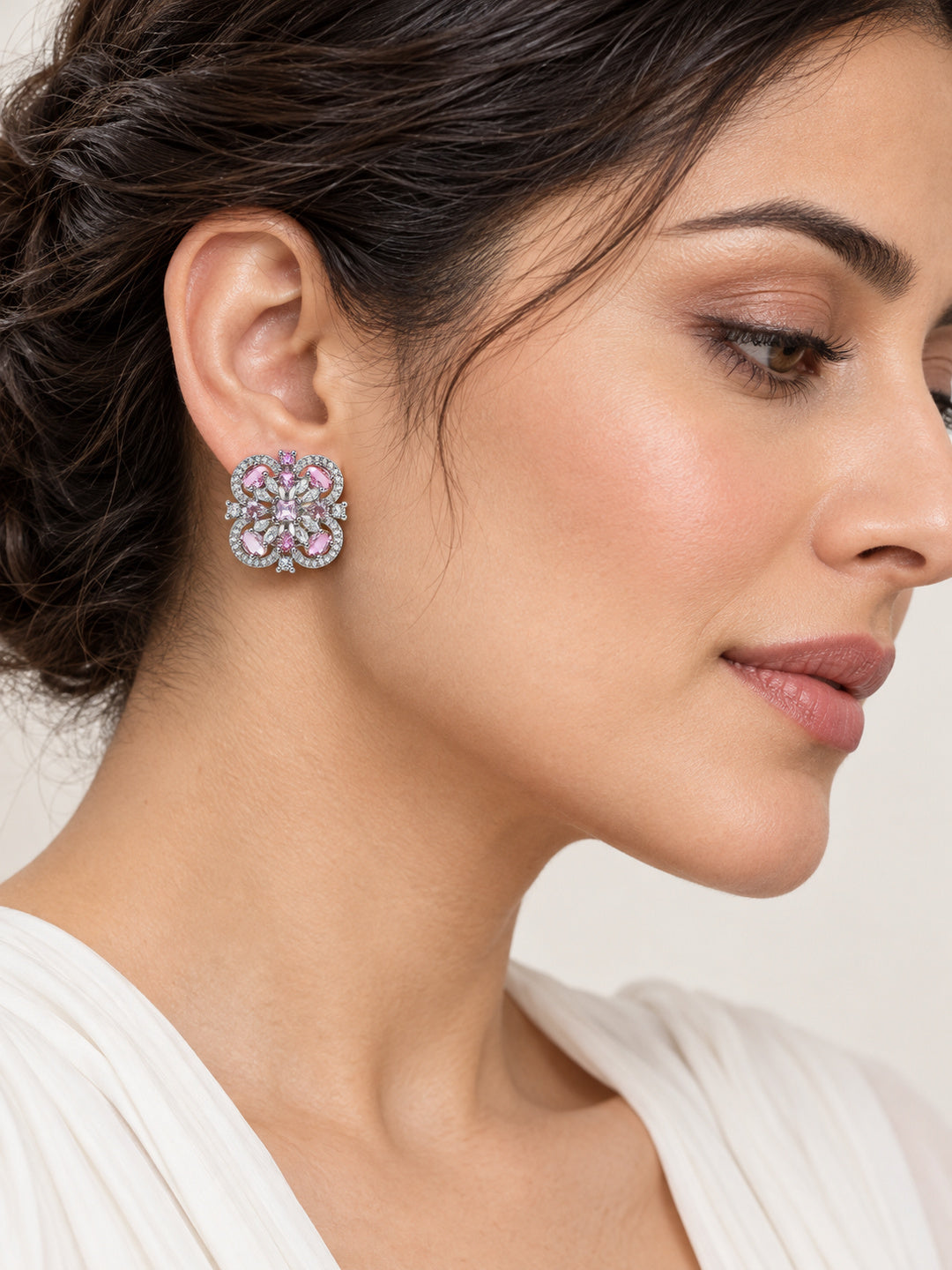 Pink Scrollwork Floral Stud Earrings in silver plating worn by a model, close-up