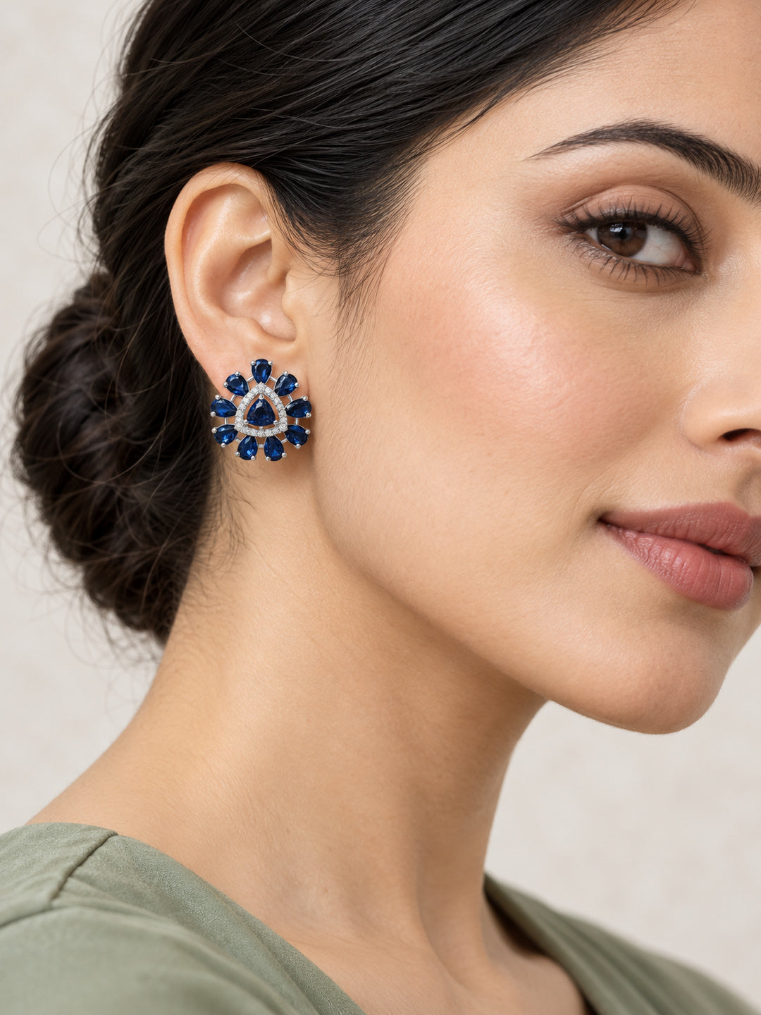 Blue Teardrop Halo Stud Earrings in silver plating worn by a model, close-up