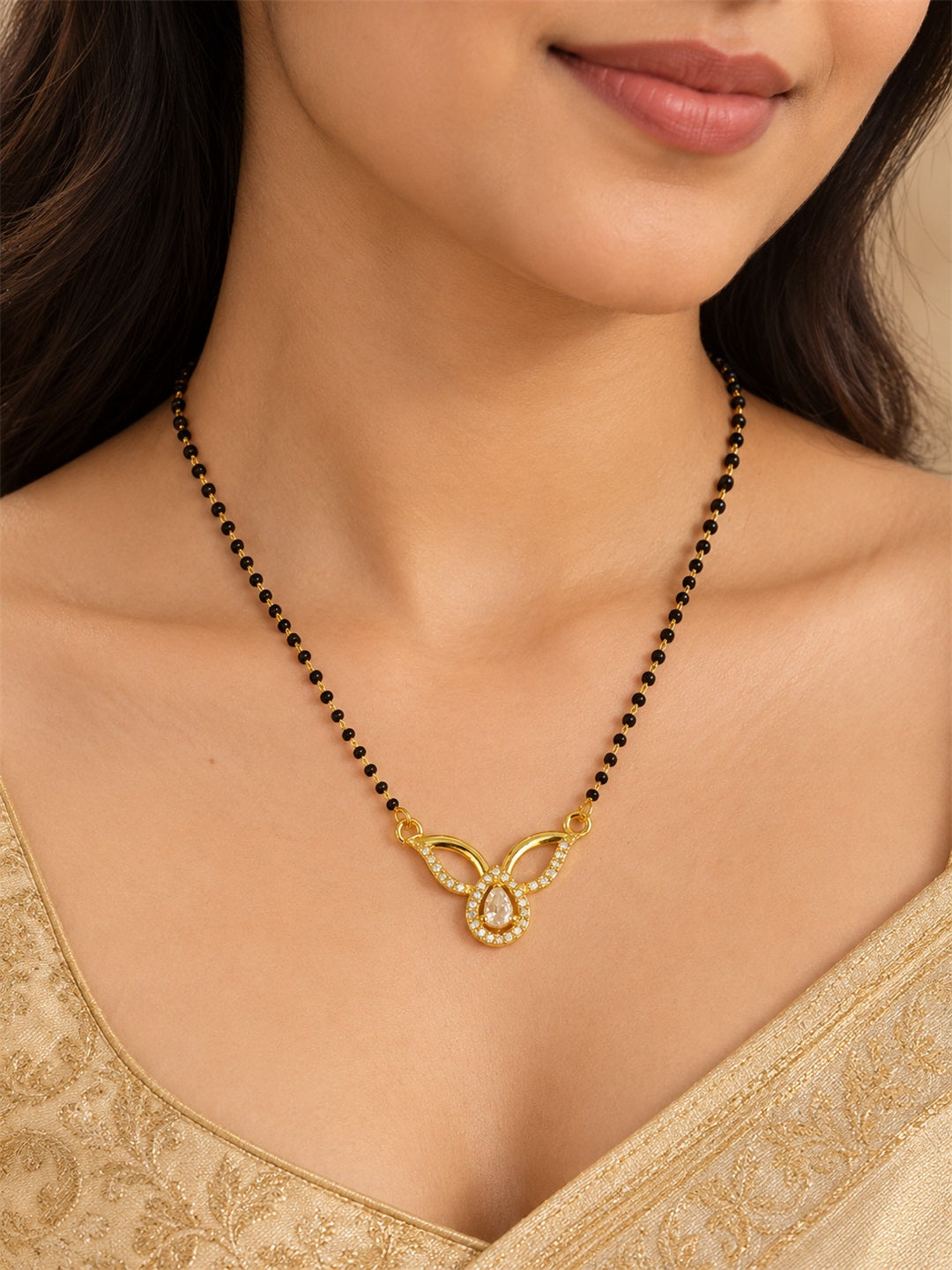 White teardrop and open leaf gold-plated mangalsutra worn by a model