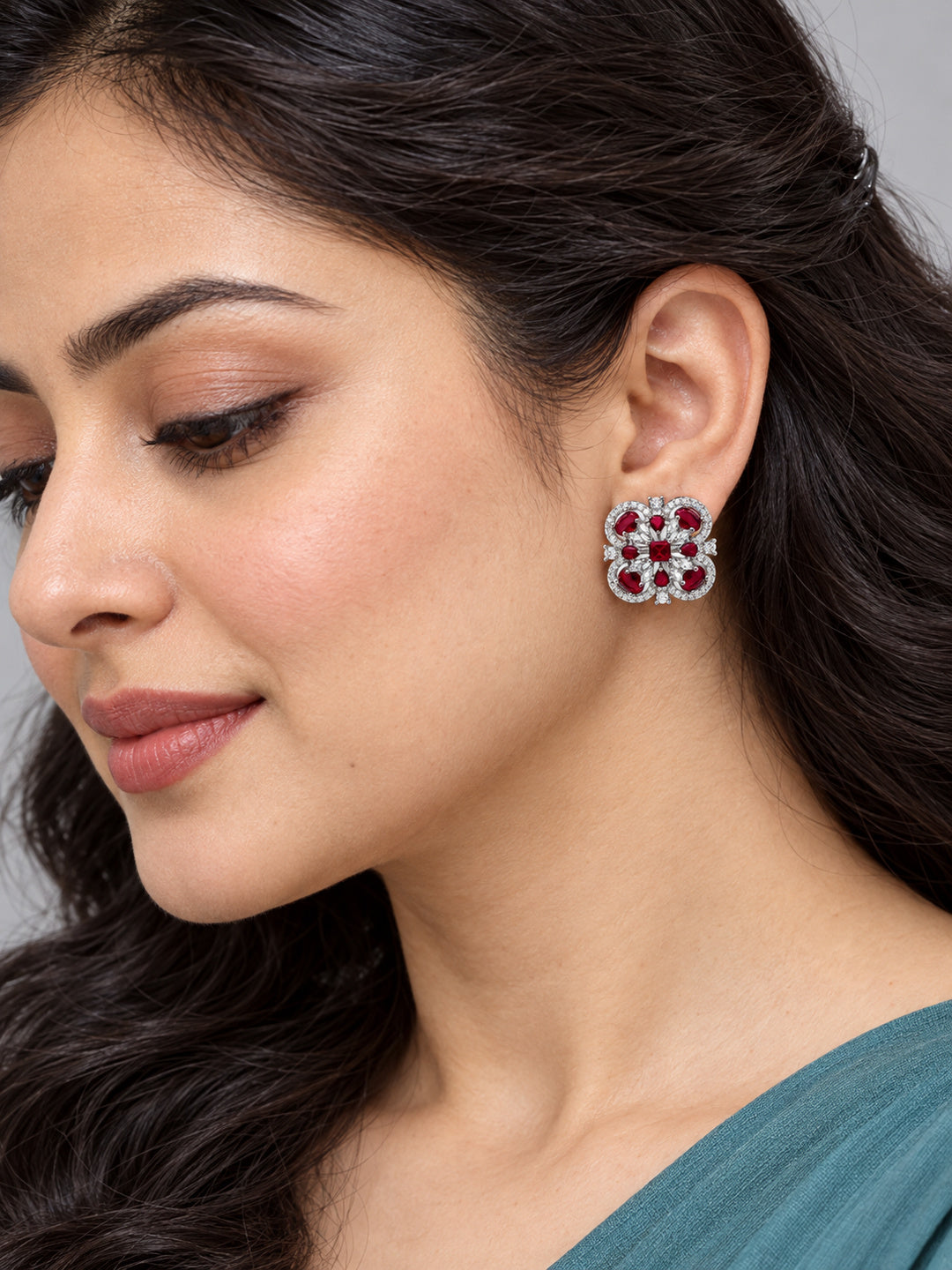 Red Scrollwork Floral Stud Earrings in silver plating worn by a model, close-up