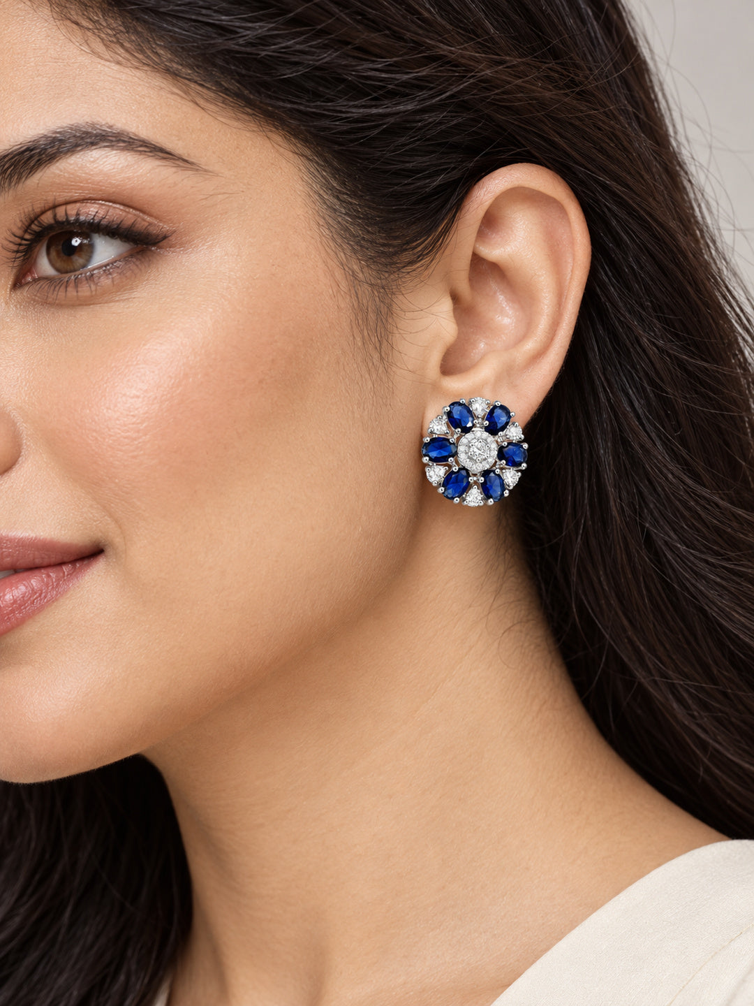 Blue Oval Stone Floral Stud Earrings in silver plating worn by a model, close-up